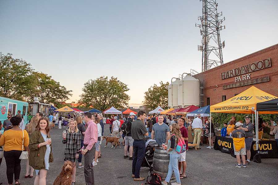 A crowd of people enjoy a brewery.