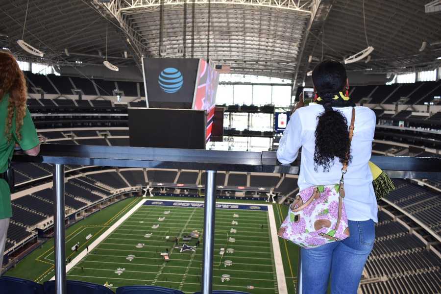 A woman looks over the railing high above a football stadium.
