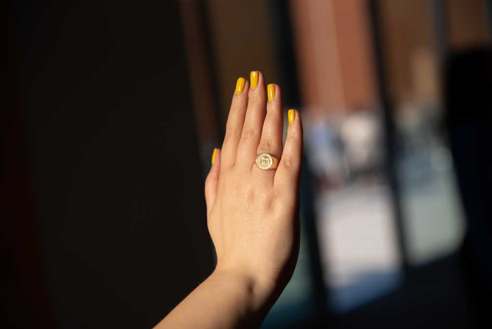 A hand wearing the V-C-U class ring.