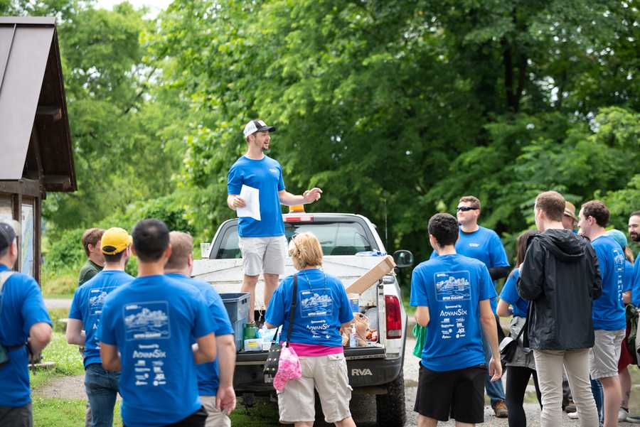 People listen to a man give directions while standing on a truck.