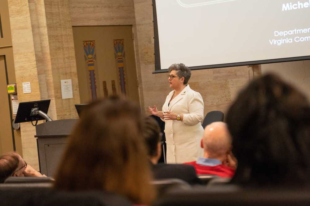 A female scientist talks to a crowd in a lecture hall.