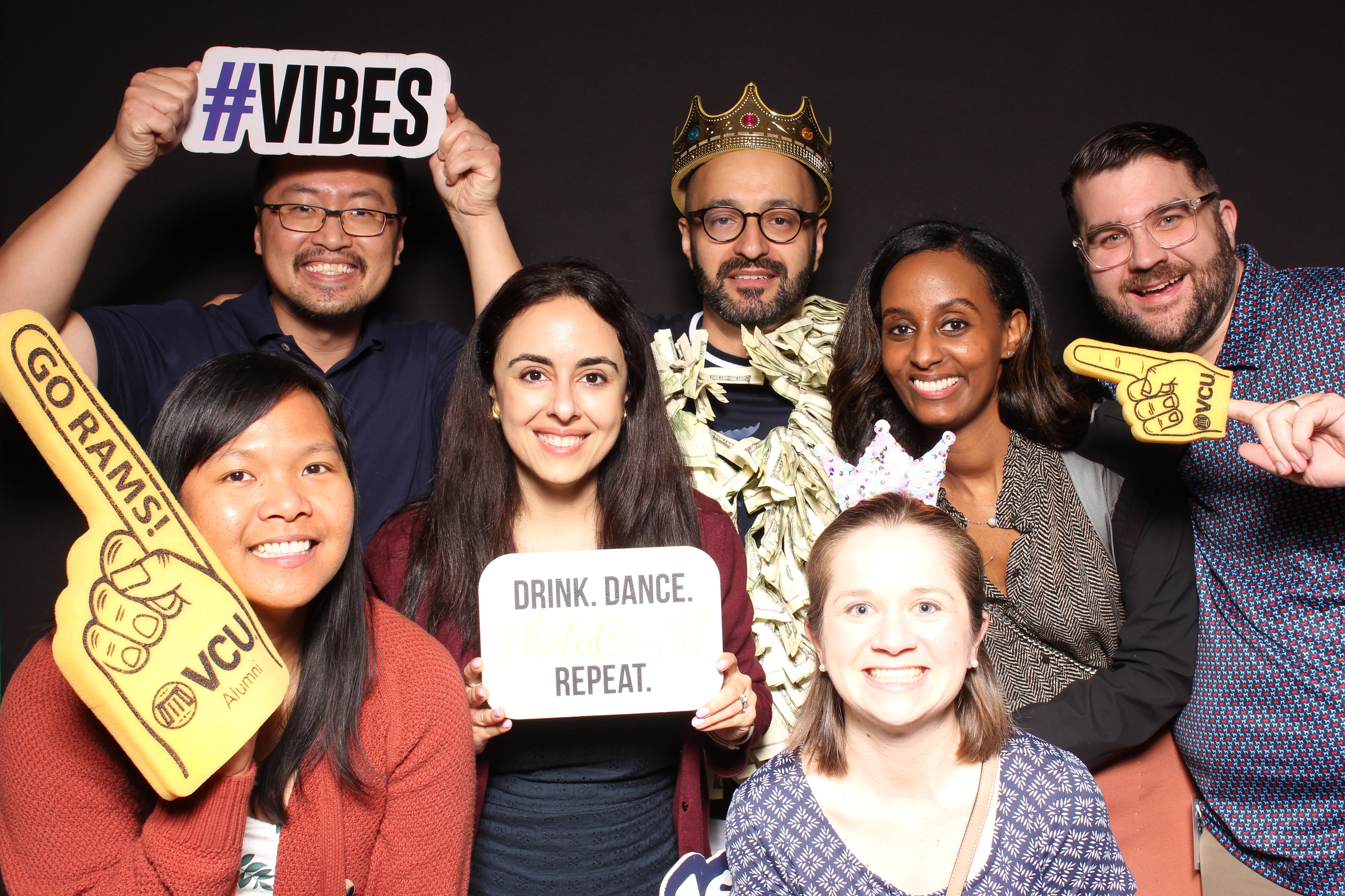 A group of people playing it up for the photobooth camera