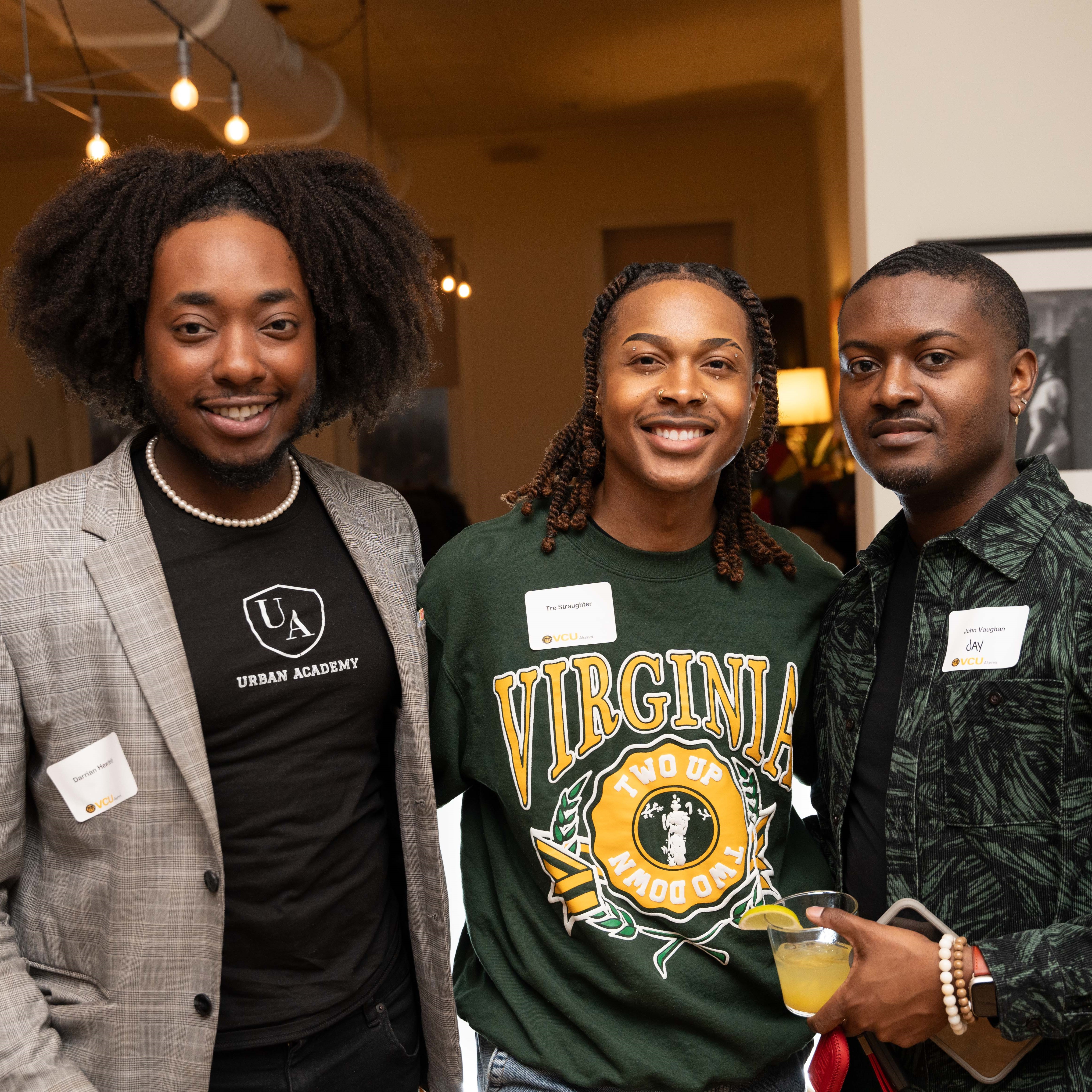Three people stand together smiling