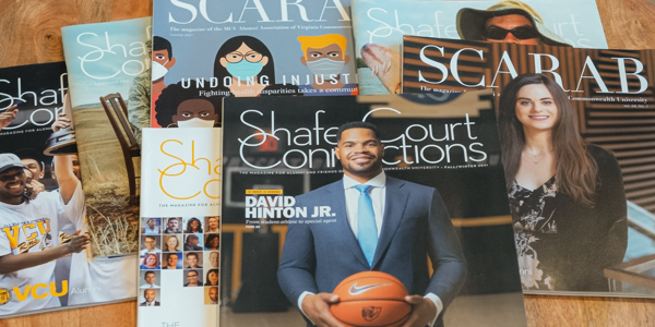A collection of past issue of Shafer Court Connections and Scarab fanned out on a table