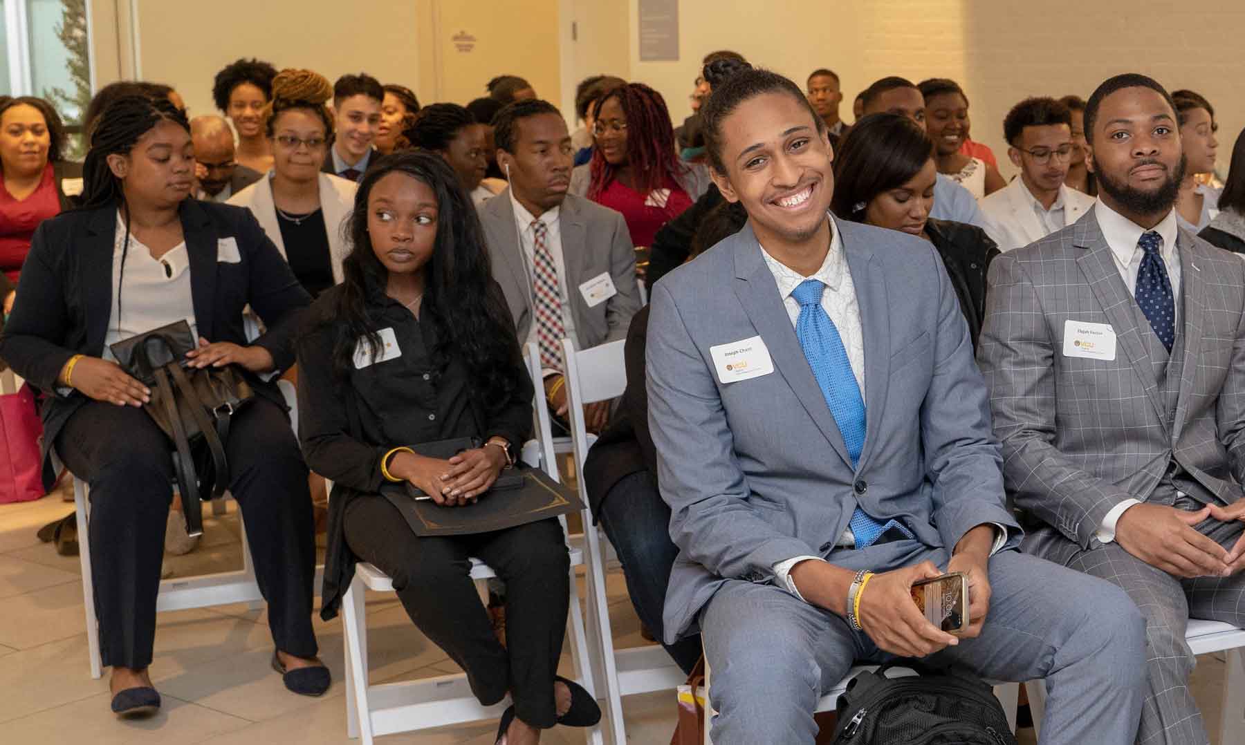 A group of Black students stiting in an auditorium